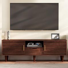 a large flat screen tv mounted to the side of a wooden entertainment center in a living room