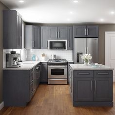 a kitchen with gray cabinets and stainless steel appliances