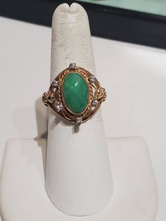 You are viewing a beautiful 14k solid gold green jade and diamond ring. The ring size : 6 3/4 The total gram weight of the ring is : 5.61 grams. The ring marked 14k inside and tested 14k. Its a very well made ring. The jade ring surround with 6 round dia total of .12 ctw. The jade stone measures 13mm x 8mm oval shape . Please take a closer look at the video and photos. If you have a question send me a message. Collectible Green 14k Stamped Jewelry, Green 14k Gold Diamond Ring For Anniversary, Green Diamond 14k Gold Ring For Anniversary, Green Diamond Ring In 14k Gold For Anniversary, Elegant 14k Stamped Emerald Ring, Green 14k Gold Diamond Anniversary Ring, Art Deco Green Emerald Ring In 14k Gold, Art Deco Emerald Ring In 14k Gold, Heirloom Jade Jewelry In Green