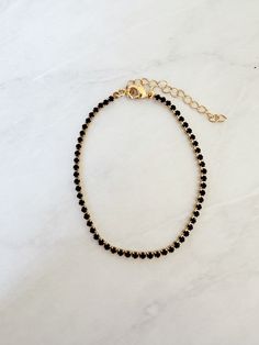 "Perfect worn on its own or layered with our other bracelets. 18k gold filled. Black cubic zirconia 6\" length + extender  Ready to ship *18k gold filled is a more affordable alternative to solid gold jewelry. Gold filled is a layer of gold bonded onto a base metal with heat and pressure that contains 100+ times more gold than gold plated jewelry.  *It is very durable and tarnish resistant.  *With proper care, gold filled jewelry can last several years. Avoid contact with harsh chemicals, perfumes, water, etc.  *Gold filled jewelry can be worn by people with sensitive skin because it is hypoallergenic, lead free and nickel free." Dainty Black Tarnish-resistant Jewelry, Black Bracelet With Adjustable Chain For Everyday, Adjustable Black Beaded Bracelet, Dainty Black Bracelet Jewelry, Adjustable Black Beaded Bracelet With Chain, Adjustable Black Tennis Bracelet As Gift, Elegant Black Beaded Bracelet With Adjustable Chain, Everyday Black Jubilee Beaded Bracelets, Black Jubilee Tennis Bracelet Gift