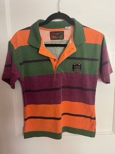 Listing is for a vintage 1990s/Y2K  Bugle Boy boys size striped shirt. Laying flat the measurements are approximately 17 inches pit to pit and 22 inches in length. Shirt is in good vintage condition. Tag size says 12-14. Comes from a non-smoking home. Thank you so much for looking.😃😃 Retro Collared T-shirt For Streetwear, Casual Multicolor Tops With Striped Collar, Vintage Green Collared T-shirt, Casual Multicolor Polo Shirt With Striped Collar, Retro Striped Polo Shirt With Polo Collar, Retro Striped Polo Shirt, Multicolor Cotton Polo Shirt With Striped Collar, Vintage Striped Polo Collar Tops, 90s Striped Short Sleeve Tops