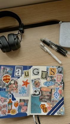 an open book sitting on top of a desk next to headphones and a pen