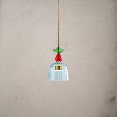 a bird feeder hanging from the ceiling with a red apple on it's top