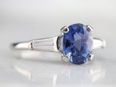 This classic and timeless mounting came to us without a stone, and so we chose a gorgeous Ceylon sapphire to bring it to completion. Crafted of platinum, the wonderfully proportioned, weighty mounting features tapered baguette diamonds on each shoulder that bring sparkle to the architectural feel of the centerpiece, and hand etching on a portion of the band to add a bit of extra texture and visual appeal. The center stone is cobalt, cornflower blue Ceylon sapphire, sparkling with gorgeous colors Platinum Sapphire Ring With Baguette Cut, Sapphire Baguette Cut Platinum Ring, Baguette Cut Sapphire Platinum Ring, Classic White Gold Sapphire Ring With Baguette Diamonds, Classic Sapphire Ring With Baguette Diamonds, Platinum Sapphire Ring, Navy Cut, Diamond Ring Platinum, Yellow Gold Sapphire Ring