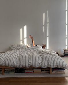 a woman laying on top of a bed in a room with bookshelves and windows