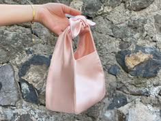 🔘 This Elegant Satin knot bag is ideal for the wedding day, night out, party, special occasion, brides, bridesmaids, mothers of the bride, or any formal fun 🔘 This  bag has an elastic opening and a stiff bottom   🔘 Please contact us for a custom order. 🔘 Material: Satin fabric or faux Silk. The lining fabric is the same fabric as on the outside. This bag has a magnetic snap closure inside. It also has a bottom shaper inside. 🔘 Measurements: Bottom Length x Height x Depth; 16 x 16 x 10 cm / Formal Purse Evening Bags, Satin Pouch Bag, Elegant Evening Bag With Satin Bow, Elegant Evening Bags With Satin Bow, Rectangular Satin Wedding Bag, Elegant Wedding Bags With Bow Detail, Elegant Wedding Bags With Bow, Elegant Shoulder Bag With Bow As A Gift, Chic Satin Evening Bag For Wedding