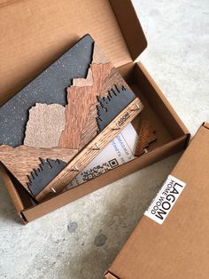 an open cardboard box with some wood pieces in it