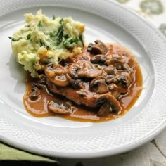 a white plate topped with meat covered in gravy