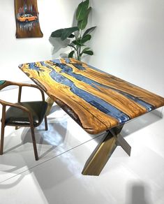 a wooden table sitting next to a chair and potted plant in a white room