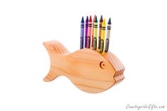 a wooden fish with colored crayons on it