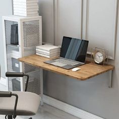 a laptop computer sitting on top of a wooden desk next to a stack of books