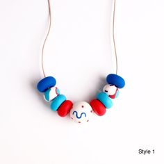 a necklace made out of plastic beads on a white background with the words style 1 written in red, white and blue