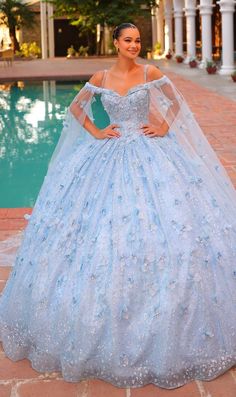 Long pastel off the shoulder quinceanera ball gown with 3D floral details and sheer cape sleeves. Sweet 15 Dresses Quinceanera Light Blue, Baby Blue Quince Dresses, Light Blue Sparkly Dress, Butterfly Quince Dress, Sweet 15 Dresses Quinceanera, Baby Blue Quinceanera Dresses, Butterfly Quinceanera Theme, Blue Quince Dress, Light Blue Quinceanera Dresses