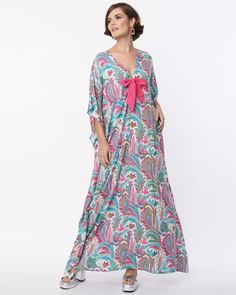 This beautiful 1970's-inspired caftan frock is the perfect addition to your wardrobe! Crafted with a lightweight fabric covered in pink and blue paisley, it features an adorable pink bow on the V-neckline and half sleeves that flow perfectly. Don't miss out - get yours now while supplies last! A must-have! Round out your vacation and weekend wardrobe with this plus size dress Unique Vintage Unique Vintage Pink & Blue Paisley Print Bow Front Caftan | Pink, Blue | Dresses | Materials & Care Instructions: ['100% Polyester', 'Hand wash', 'Imported'] Bohemian Paisley Print Daywear Dresses, Summer Paisley Print Kaftan, Pink Paisley Print Dresses For Vacation, Pink Paisley Print Maxi Dress For Beach, Pink Paisley Print Beach Dress, Summer Pink Paisley Print Maxi Dress, Pink Paisley Print Maxi Dress For Summer, Pink Paisley Maxi Dress For Summer, Paisley Print Kaftan For Vacation