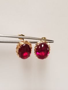 "Thanks for shopping our vintage estate store. We tend to sell well below wholesale and truly hope you enjoy all of our items. Many of the items are one of a kind, so please enjoy scrolling through the pictures and hopefully something will catch your eye. Brown spots are from camera or reflections. Nice estate 18k yellow gold natural 6ct ruby or spinel stud earrings. Assuming these are spinel, testing ruby, but a lot of these types of gems will test natural and may even be created. Size: 1/2\" by 3/8\" Ruby: 11mm by 8mm Weight: 3.83 grams Gems: 3ct each ruby Marked 18k and these are stunning. These are antique earrings." Elegant Oval Cabochon Earrings For Formal Occasions, Yellow Gold Cabochon Earrings For Anniversary, Elegant Formal Oval Cabochon Earrings, Antique Round Clip-on Earrings For Anniversary, Formal Cabochon Fine Jewelry Earrings, Formal Cabochon Earrings In Fine Jewelry Style, Classic Ruby Earrings For Formal Occasions, Formal Clip-on Earrings With Oval Cabochon, Elegant Oval Cabochon Earrings For Anniversary