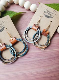 two pairs of wooden hoop earrings sitting on top of a table