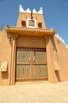 an adobe style building with two colorful doors