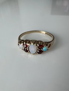 Vintage 9k Garnet & Opal Ring Center Opal Oval:5.2mm x 3.6mm, Side Round Opals: 1.9mm Diameter, 4 2.2mm Garnet round stones English Hallmarks Size:5.5 1.38g Vintage Multi-stone 14k Gold Opal Ring, Vintage 14k Gold Multi-stone Opal Ring, Antique Multi-stone Opal Ring For Anniversary, Classic Opal Birthstone Ring, Classic Multi-stone Opal Ring For Formal Occasions, Vintage Oval Opal Birthstone Ring, Classic Multi-stone Opal Ring, Classic Oval Multi-stone Cluster Ring, Classic Multi-stone Birthstone Ring