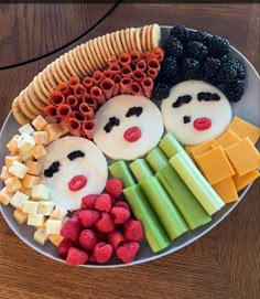 a white plate topped with fruit and veggies on top of a wooden table