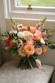 a bouquet of flowers sitting on top of a bench next to a window sill