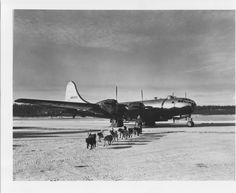 black and white photograph of people walking towards an airplane