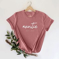 Auntie Est Shirt, Aunt Shirt, Customized Auntie Est Shirt, Birthday Gift Aunt Shirt, New Aunt Shirt, Cool Aunt T-Shirt, Aunt Life Shirt, Auntie Est Shirt,Aunt Shirt,Customized Aunt Tee,Bday Gift Aunt Shirt,New Aunt Shirt,Cool Aunt T-Shirt,Aunt Life Shirt,Auntie to be Shirt,Favorite Aunt Shirt,Baby Shower Shirt,Christmas Aunt Tee,Cute Aunt Shirt,Gift for Aunt Shirt  Welcome to my store! I'm absolutely thrilled to have you here. My main aim is to ensure your happiness and satisfaction. I value our Casual Birthday Tops With Letter Print, Casual Letter Print Top For Birthday, Birthday Short Sleeve Tops With Funny Text, Birthday Tops With Funny Text And Short Sleeves, Casual Slogan Tops For Birthdays, Birthday Tops With Letter Print And Short Sleeves, Short Sleeve Tops With Letter Print For Birthday, Casual Slogan Tops For Birthday, Birthday Shirt With Letter Print And Short Sleeves