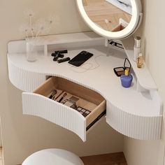 a white vanity with a mirror above it and drawers underneath the counter top, in front of a toilet