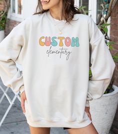 Wrap yourself in school spirit with our adorable custom crewneck, proudly displaying the name of your cherished elementary school. This sweatshirt not only showcases your school pride but also adds a touch of cuteness with a charming design. Ideal for dual language educators seeking a thoughtful and unique gift, this custom crewneck is perfect for showcasing your dedication to your school community. 📚 Ideal for dual language educators and teachers seeking personalized and meaningful gifts. 👕 P Casual Custom Print Sweatshirt For College, Customizable Crew Neck Sweatshirt For School, School Spirit Cotton Sweatshirt With Name Print, Cotton Sweatshirt With Name Print For School Spirit, School Crew Neck Sweatshirt With Name Print, College Crew Neck Sweatshirt With Custom Print, Casual Customizable Sweatshirt For Fall, Casual Fall Sweatshirt For Customization, Collegiate Letter Print Sweatshirt For School