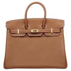 Hermes Gold Togo Leather 25cm Birkin Bag w/ Gold Hardware Made In: France Year of Production: 2019 Color: Gold- tan Hardware: Goldtone Materials: Togo leather Lining: Chevre leather Closure/Opening: Flap top with two draw strap closures and turnlock Interior Pockets: One zipper, one patch Exterior Condition: Excellent with light wear throughout Interior Condition: Excellent Includes: Hermes dust bag, box, lock, keys, clochette Measurements: 25cm 9.8"L x 8"H x 5.25"D Handle Drop: 2.5" Togo Leather, Birkin Bag, Fashion Handbags, Gold Hardware, Made In France, Dust Bag, Top Handle Bag, Zipper, Handbags