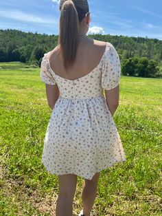 Introducing our Rosette Babydoll Dress, the perfect addition to your summer wardrobe. Made from 100% cotton, this floral mini dress exudes femininity and grace. The model is 5'3" and wearing a size small. Stay cool and stylish all summer long with this must-have dress that runs true to size. Size rec: S - 2-4 M - 4-6 L - 8-10 Square Neck Ditsy Floral Dress For Day Out, Summer Floral Print Mini Dress With Puff Sleeves, Floral Print Puff Sleeve Sundress, Cotton Floral Dress For Day Out, Summer Floral Dress With Ditsy Print And Square Neck, Summer Ditsy Floral Print Dress With Square Neck, Summer Cotton Floral Dress For Daywear, Feminine Cotton Floral Dress For Beach, Cute Sundress With Ditsy Floral Print