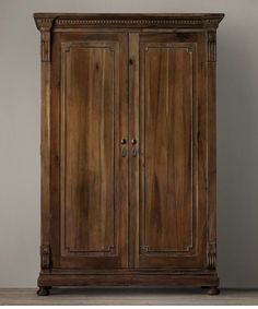 an old wooden armoire sitting on top of a hard wood floor next to a wall