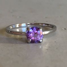 "A TINY round-shape faceted genuine Purple Amethyst hand set in a 4-prong setting featuring a tapered sterling silver shank. This beauty makes a great birthstone ring for those February Birthday gals or a lovely stackable ring for her! Wrapped in a box ready for gift-giving. (r-egt-146) Ring info ------------------------- Genuine Purple Amethyst measures 5mm Sterling Silver *Follow us @belesasjewelry on Instagram for promotions/giveaways *LIKE* us on Facebook http://www.facebook.com/Belesas to f Faceted Sapphire Promise Ring, Faceted Sapphire Fine Jewelry Ring, Faceted Sapphire Ring Fine Jewelry, Classic Amethyst Round Band Ring, Classic Amethyst Ring With Round Cut, Classic Purple Round Band Ring, Classic Amethyst Round Cut Birthstone Ring, Classic Amethyst Birthstone Ring With Round Cut, Fine Jewelry Amethyst Solitaire Ring