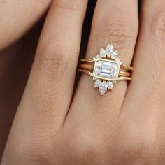 a woman's hand with two gold rings and a diamond ring on top of her finger