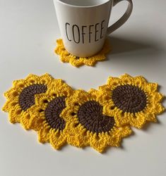 two crocheted sunflower coasters next to a coffee cup