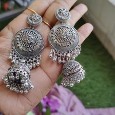 Elevate your jewelry collection with these stunning Oxidized Silver Jhumka Earrings, inspired by traditional Kashmiri craftsmanship. Handcrafted with meticulous attention to detail, these earrings feature intricate floral motifs and exquisite filigree work that perfectly captures the essence of Indian heritage. The large circular design is complemented by delicate ghungroo bells, adding a playful jingle with every movement. Ideal for festive occasions, weddings, and casual outings, these stateme Bollywood Style Metal Earrings For Gift, Bollywood Latkan Earrings As Gift, Bollywood Style Latkans Earrings For Gift, Bollywood Style Latkan Earrings For Gift, Bollywood Style Latkans Earrings As Gift, Metal Dangle Chandbalis For Celebration, Metal Earrings With Latkans For Celebration, Metal Chandbalis In Dangle Style For Celebration, Metal Chandbalis For Celebration With Dangle Shape