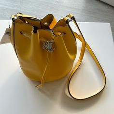 New Ralph Lauren Yellow Leather Bucket Bag Tote Purse. $175. Height: 8.5”. Width: 7.25”. Depth: 5.5”. Chic Ralph Lauren Shoulder Bag For Shopping, Chic Ralph Lauren Satchel Bag, Chic Ralph Lauren Shoulder Bag, Everyday Ralph Lauren Bags With Gold-tone Hardware, Classic Bucket Bag With Branded Hardware, Yellow Rectangular Bag With Silver-tone Hardware, Yellow Bags With Silver-tone Hardware For Everyday Use, Luxury Yellow Bags With Silver-tone Hardware, Chic Ralph Lauren Travel Bag