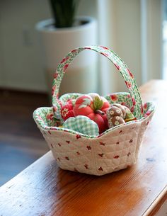 a small basket filled with lots of different types of fruit on top of a wooden table