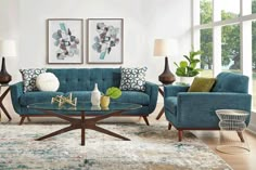 a living room filled with blue couches and pillows on top of a wooden table