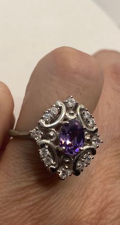 This is a vintage purple amethyst with amethyst sidestones set in 925 sterling We have in size 7 this can be sized to your specification, our jeweler charges $10-$20 please message us to discuss sizing your ring or engraving options. All of our jewelry is hand polished and shipped to you in a stylish gift box. We are happy to gift wrap for you. It is important to us that each customer be thrilled with their purchase. We are grateful for thousands of positive reviews. Formal Amethyst 925 Stamped Jewelry, Classic Amethyst Ring With Accent Stones, Classic Amethyst Birthstone Ring, Classic Amethyst Ring With Accent Stones In Cubic Zirconia, Classic Amethyst Ring With Cubic Zirconia Accent Stones, Formal Purple Birthstone Ring With Halo Setting, Elegant Purple Birthstone Ring With Center Stone, Formal Purple Halo Birthstone Ring, Purple Jewelry For Formal Occasions