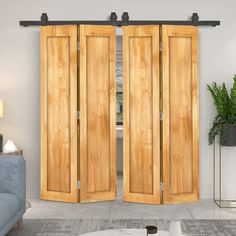 a living room with two wooden doors and a blue couch in front of the door