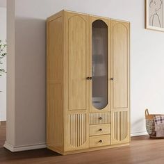 a tall wooden cabinet sitting in the corner of a room next to a basket and plant