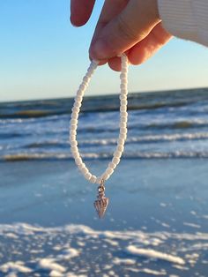 A white seed bracelet with a beautiful shiny seashell charm in the middle. Really cute and matches every outfit, perfect for kids and adults. Comes w/ 1 free sticker! Adjustable White Stretch Bracelet With Beachy Style, White Adjustable Stretch Bracelet With Beachy Style, White Shell-shaped Bracelet As A Gift, White Shell-shaped Bracelet For Gift, Handmade White Shell-shaped Bracelets, White Ocean-inspired Jewelry With Round Beads, White Adjustable Beachy Stretch Bracelet, Ocean-inspired White Round Bead Jewelry, Ocean-inspired White Round Beaded Jewelry