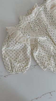 Discover the perfect blend of style and comfort with our Eloise Lace Trim Romper. Featuring a charming polka dot print and delicate lace ruffles, this romper is made from soft cotton for your baby's ultimate comfort. With a high neck and lace trim, your little one will look adorable all day long. Spring Cotton Bubble Romper With Ruffle Sleeves, Summer Bubble Romper With Ruffles And Puff Sleeves, Spring Sleepwear With Lace Trim, Summer Puff Sleeve Bubble Romper With Ruffles, Spring Bubble Romper With Puff Sleeves And Ruffles, Cottagecore Sleepwear With Lace Trim For Home, Cute Cream Bubble Romper With Ruffles, Cotton Bubble Romper With Ruffle Sleeves, Cream Long Sleeve Bubble Romper For Summer