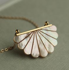 This beautiful Art Deco pendant necklace is pure Mother of Pearl which has been carved into a simple scalloped semi-circle shape.  The pearl has an incredible sheen and take on a subtle glow when they catch the light.  The pendant is finished with a delicate and fine gold plated chain.   This necklace is available in a choice of chain lengths.  Please refer to our illustrated guide for a better idea of how they might look when worn.   🖤 FASTER SHIPPING 🖤 Need this fast? We offer a Faster Shipp Sterling Silver Shell Pendant Necklace As Gift, Mother Of Pearl Engraved Necklace For Gift, Handmade Mother Of Pearl Jewelry For Anniversary, Engraved Mother Of Pearl Necklaces For Gifts, Unique Mother Of Pearl Jewelry For Wedding, Handmade Art Deco Round Necklace, Unique Shell Pendant Necklace As Gift, Unique Shell Pendant Necklace For Gift, Unique Pendant Shell Necklace As Gift