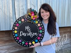 a woman is holding up a sign that says, my grandson with polka dots on it