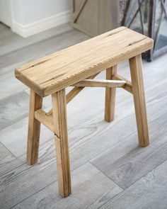 a wooden bench sitting on top of a hard wood floor next to a door and window