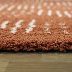 a brown and white rug on top of a wooden floor