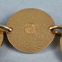 Features: - 100% Authentic CELINE PARIS. - Alternate beige enamel Celine horse carriage logo and plain gold tone medallions.. - Gold tone hardware. - Toggle closure. - Signed CELINE ABH1 Made in France. - Slip on bracelet. - Minor surface scratches. - Good vintage condition. Measurements: Height: 1.22 inches (3.1 cm) Wearable Length: 7.68 inches (19.5 cms) **This bracelet will be shipped via Priority Shipping with tracking number. Please convo me for any queries and additional photos. Thank you Gold-tone Formal Bracelets With Logo Charm, Formal Gold-tone Bracelets With Logo Charm, Gold-tone Jewelry With Logo Charm For Formal Occasions, Formal Metal Jewelry With Logo Charm, Vintage Jewelry With Gold-tone Logo Plaque, Adjustable Gold Bracelets With Gold-tone Logo, Vintage Gold Bracelet With Logo Charm, Gold Jewelry With Logo Charm For Collectors, Formal Gold Bracelets With Logo Charm