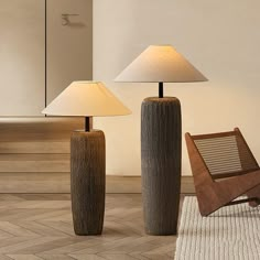 two lamps sitting next to each other on top of a wooden floor