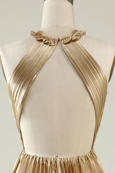 the back of a gold dress with pleating on it